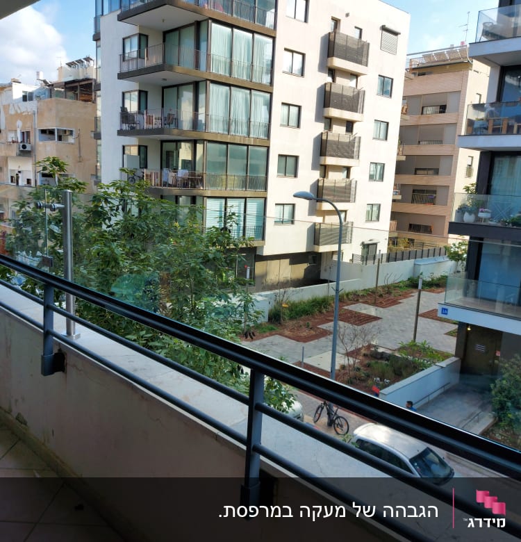 מעקה זכוכית במרפסת עם נוף לבניינים